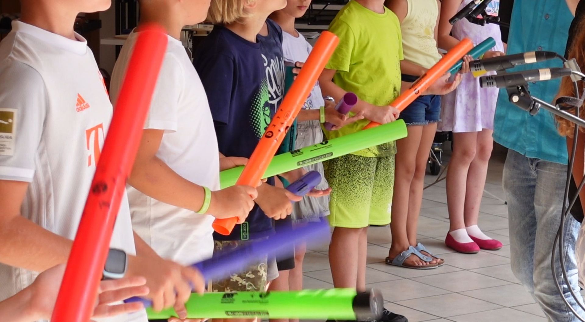 Kinder spielen bei einem Auftritt der Schulklasse auf den Boomwhackers zu den Heften des LeuWa-Verlages