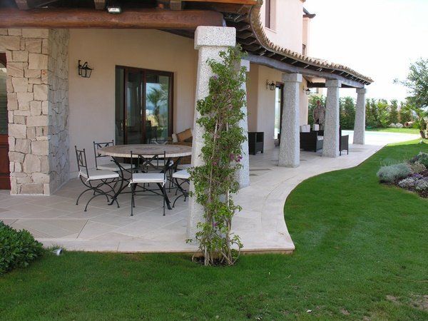 Pilastri in granito bocciardato e pavimento veranda in Travertino Alabastrino spazzolato