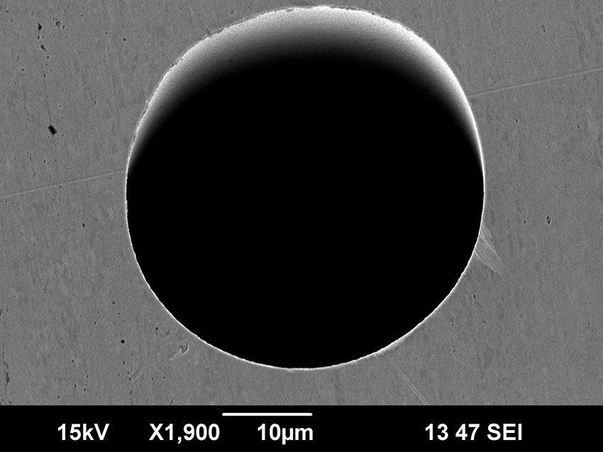 Hole with a sharp edged exit side drilled with an ultrashort pulse laser