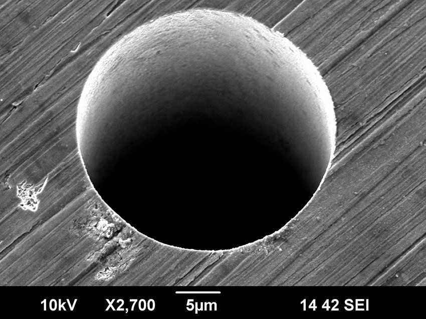30 µm diameter hole drilled in steel with an ultrafast laser