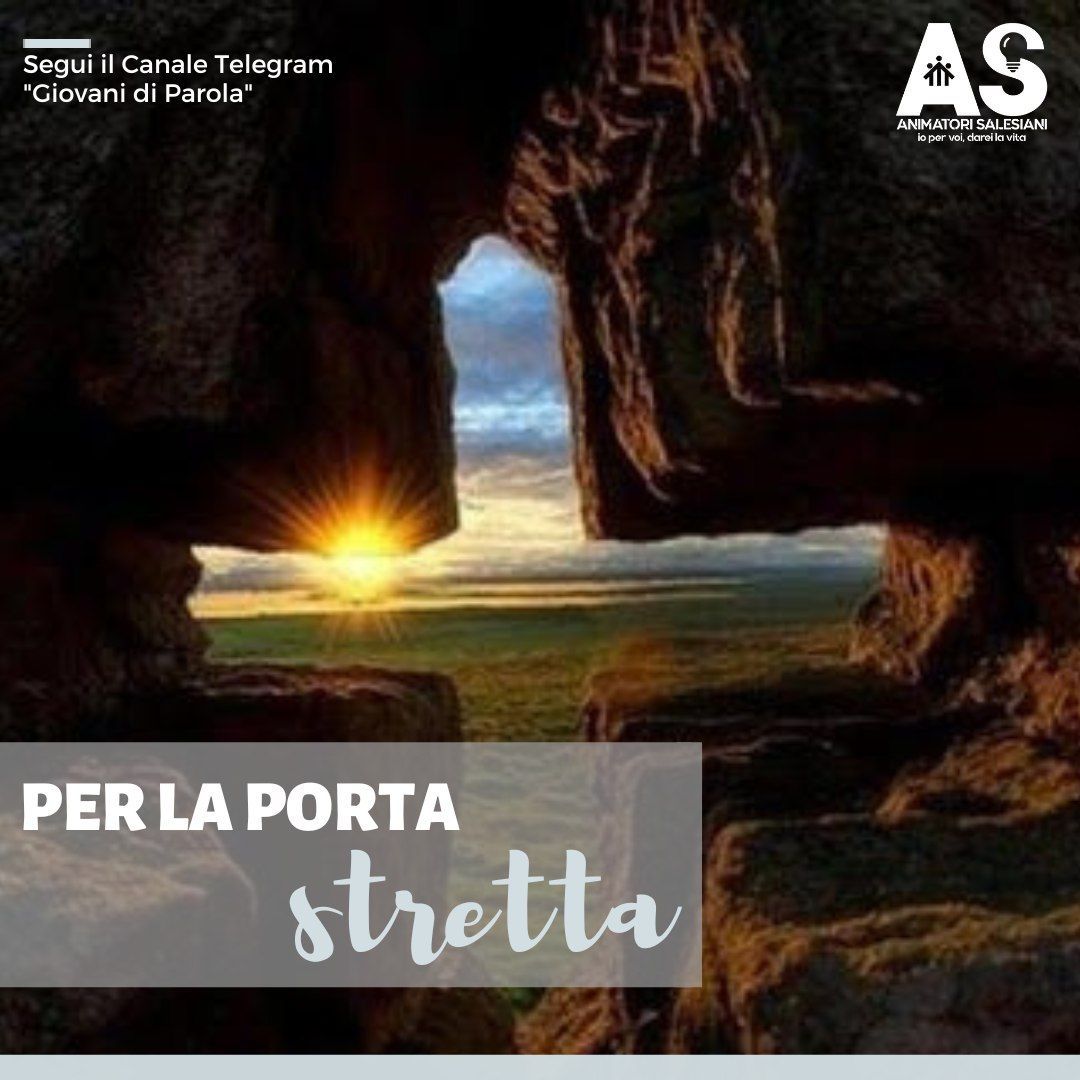 Foto di una breccia nella roccia a forma di croce latina, attraverso la quale si vede un tramonto su una foresta all'orizzonte.