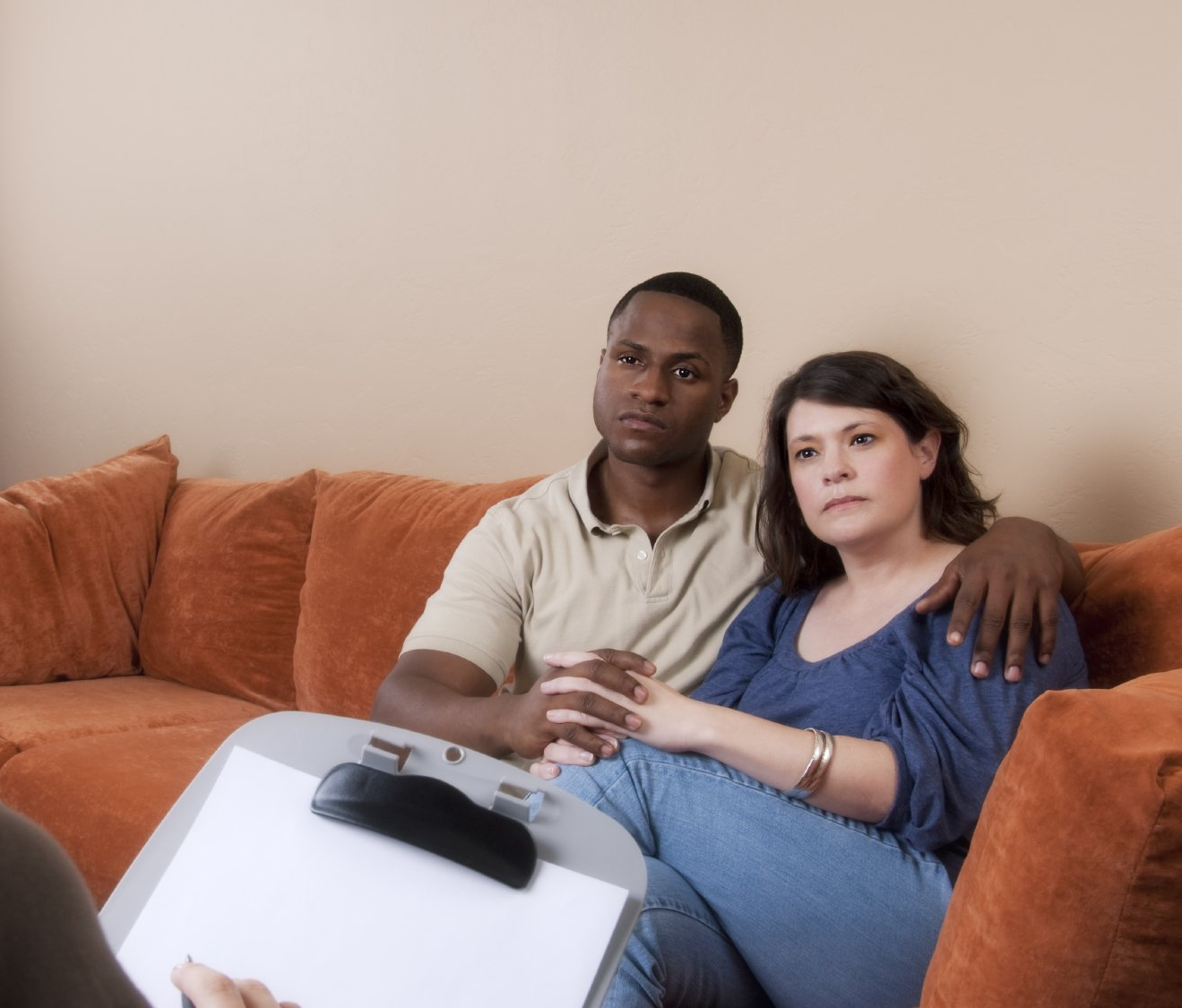 a couple sitting on a sofa in therapy