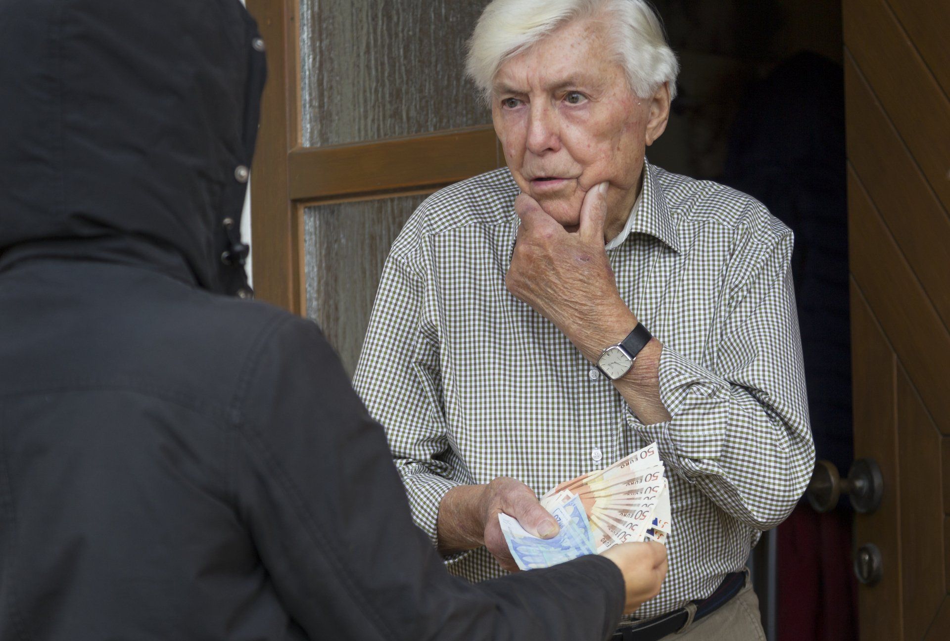 Alter Mann gibt einem Betrüger Geld Alter Mann gibt einem Betrüger Geld
