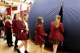 Secondary school students getting into a Science Dome UK planetarium set up at their school.