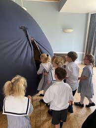 Pre-School pupils getting into a Science Dome UK planetarium set up in their school hall.