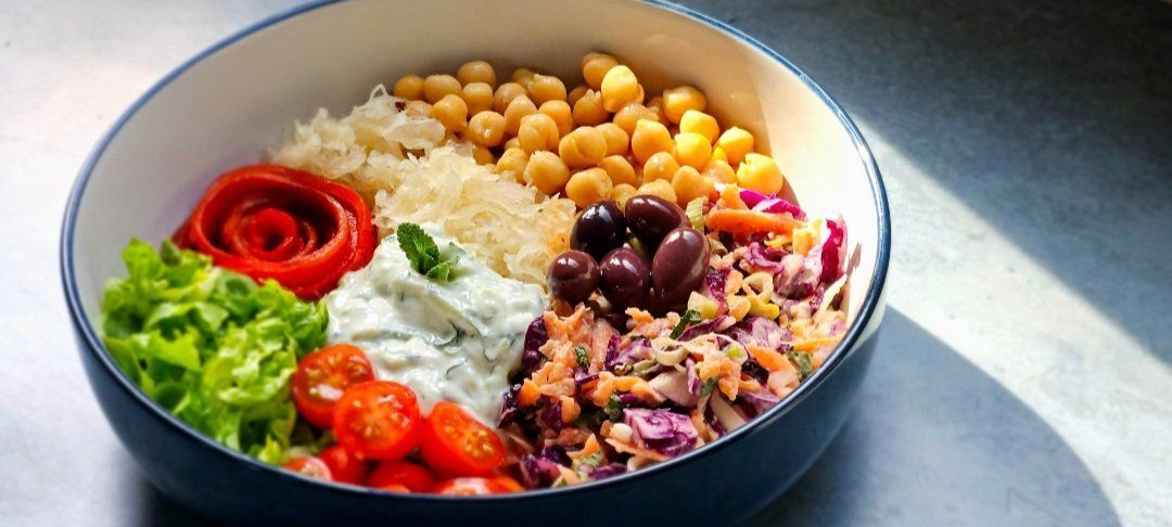 Rainbow Salad Bowl with slaw, chickpeas, minty sauce, and a red pepper rose