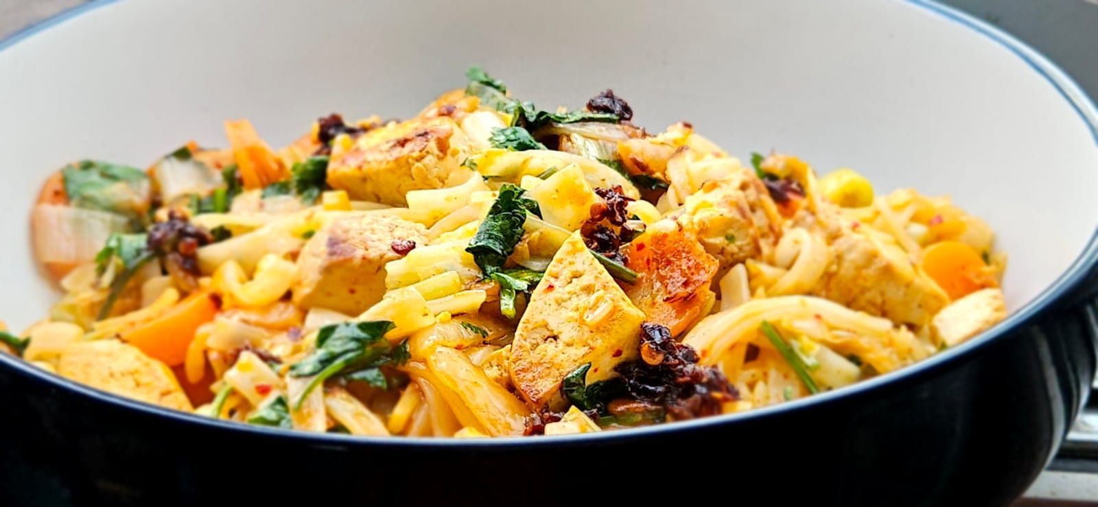 Kimchi noodle stir fry with tofu on a large bowl