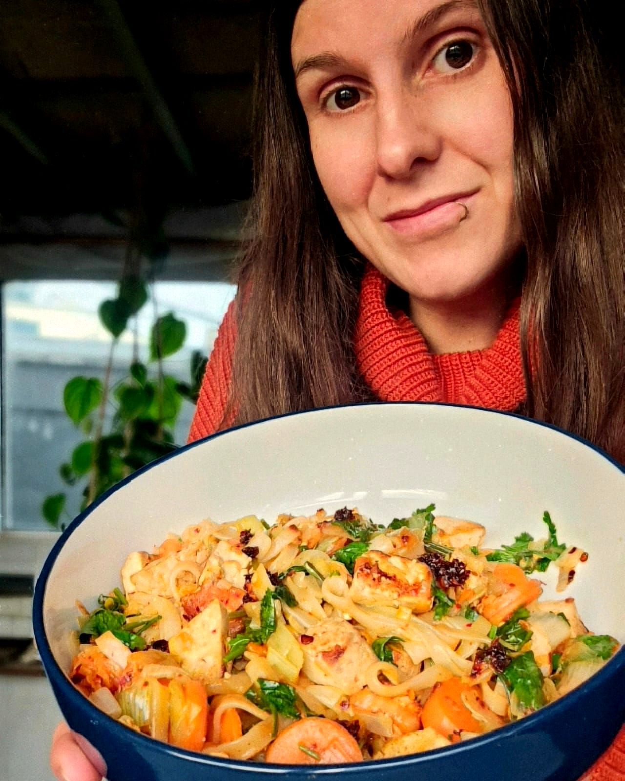 Kimchi noodle stir fry with tofu on a large bowl with rose