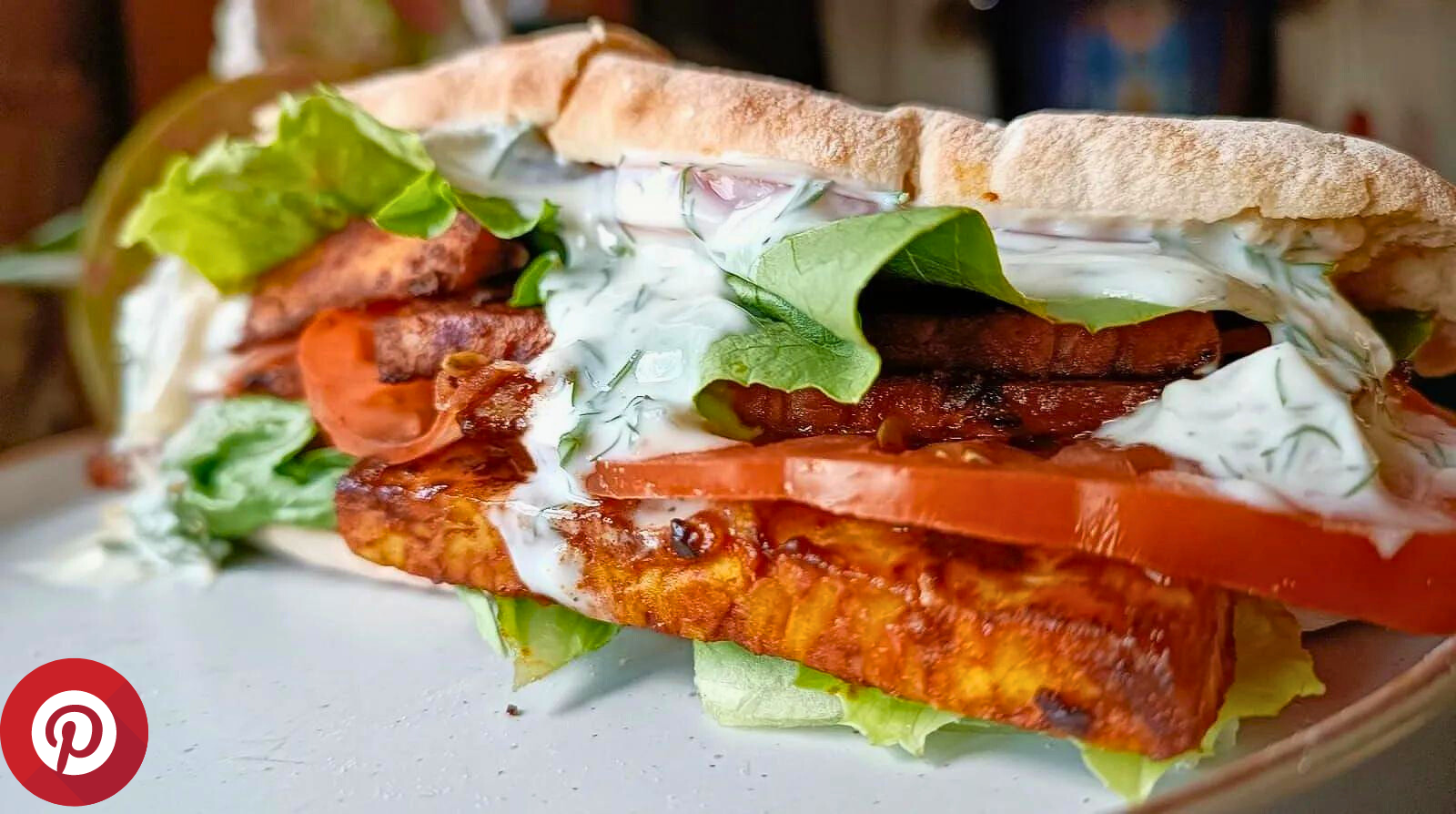 tempeh blt in a pita bread with tomato, lettuce, and dill pickle sauce