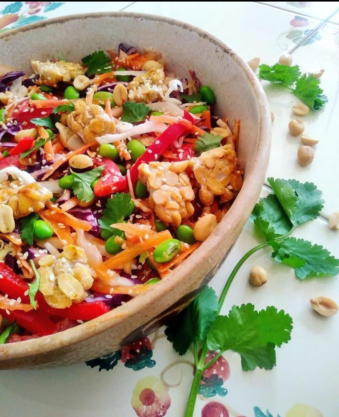 A big serving platter of salad with raw vegetables and tempeh