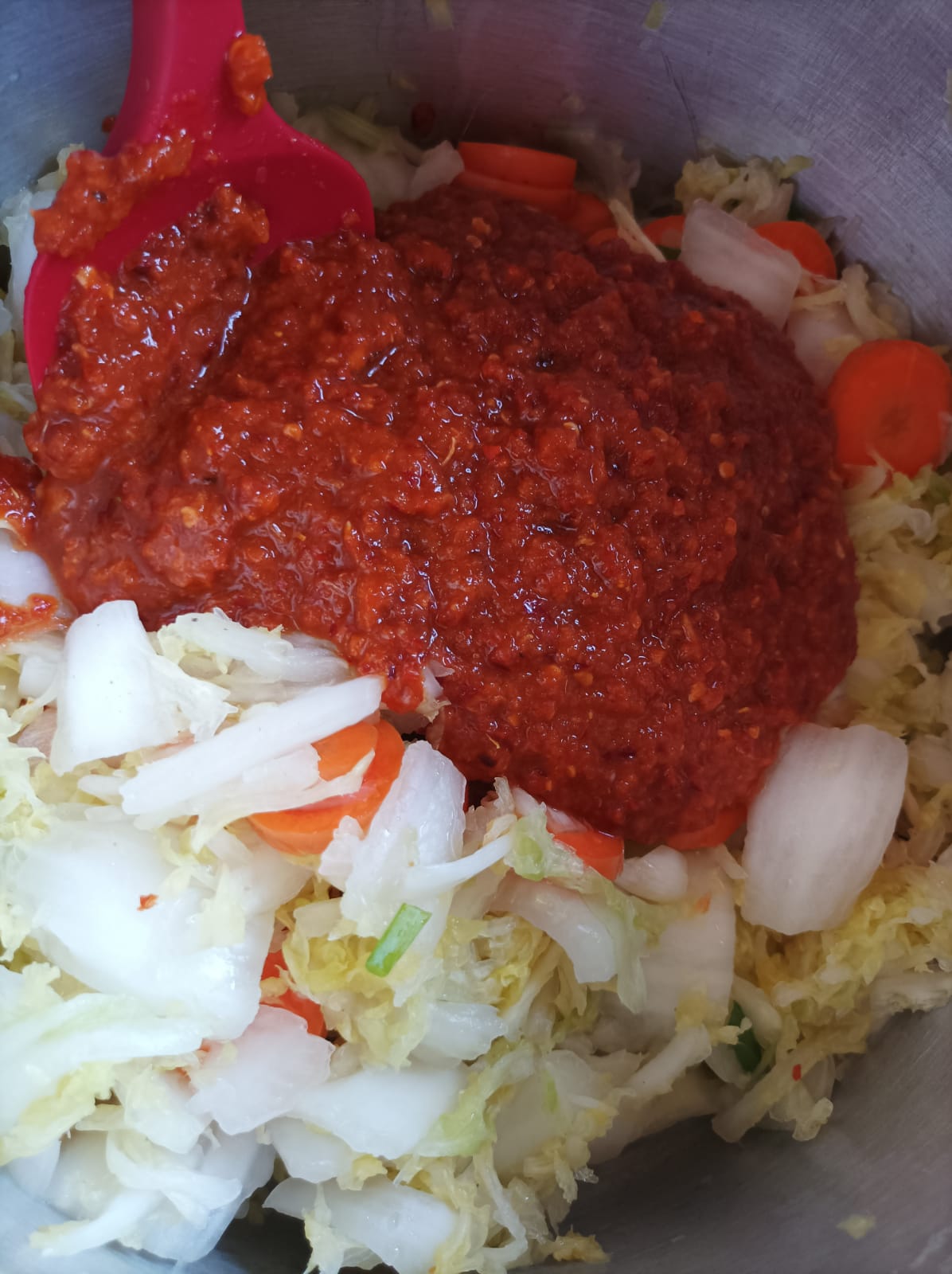 Kimchi vegetables in a saucepan adding sauce