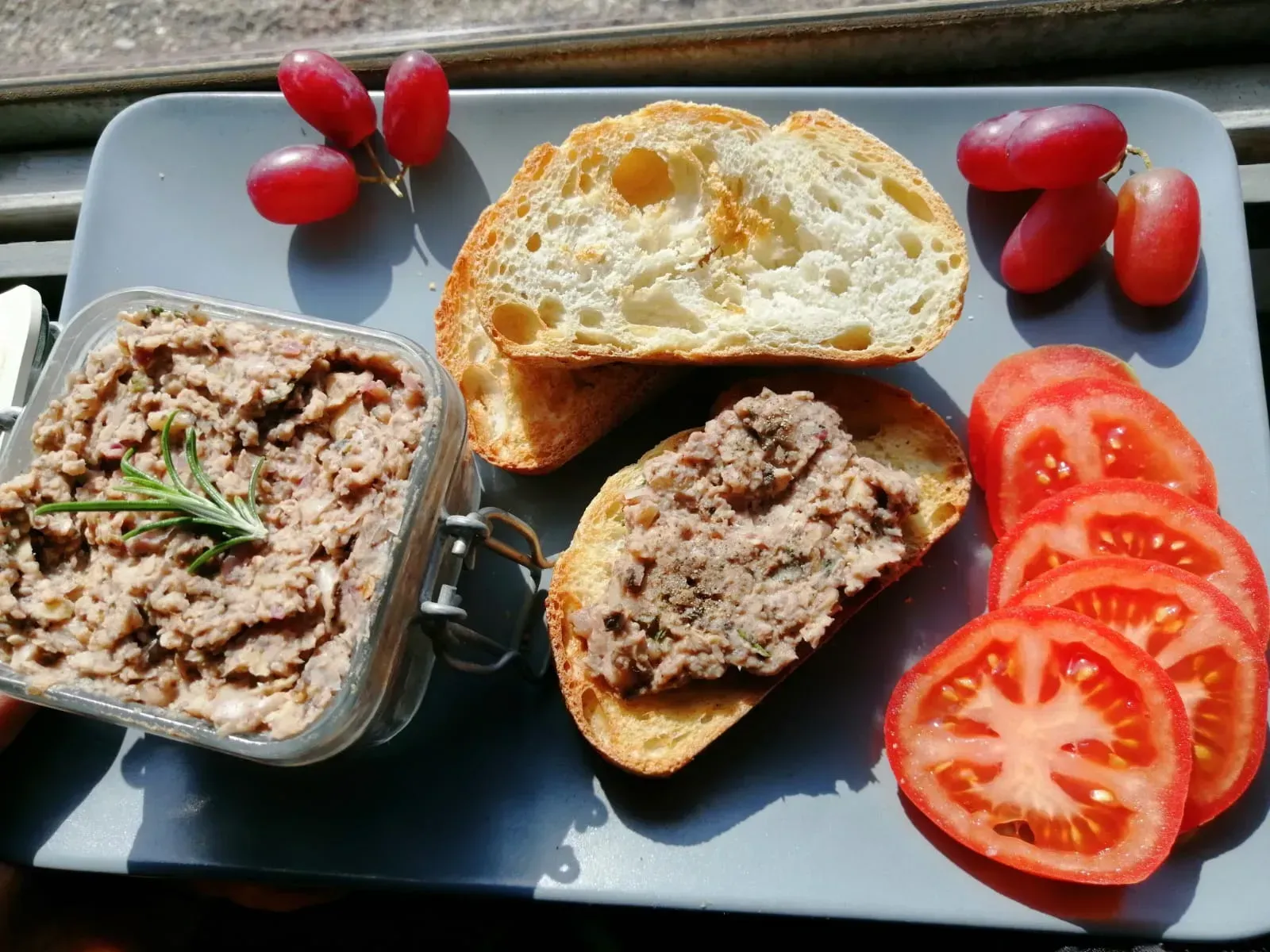 bean and walnut pate on toast with sliced tomatoes and grapes