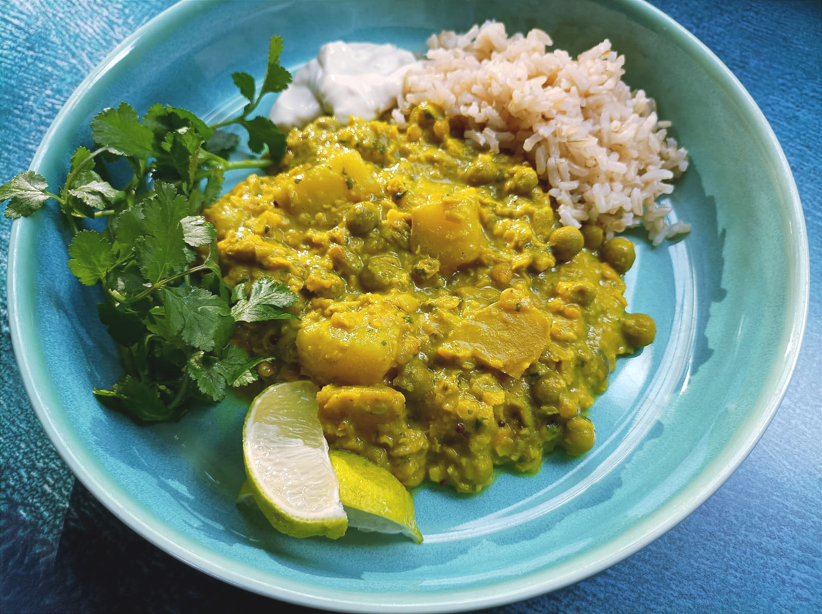 Coconut Green Curry with rice, fresh coriander, lime, and yogurt
