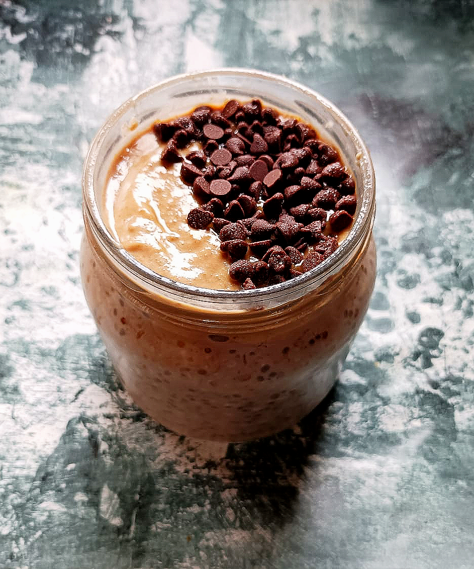 A jar filled with salted caramel overnight oats and topped with chocolate chips