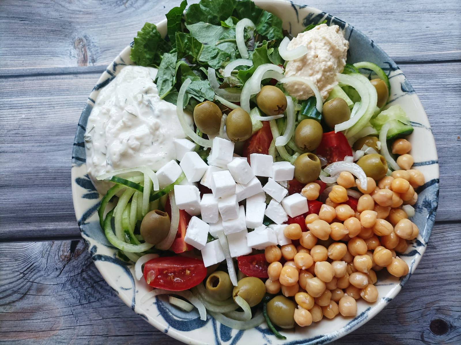 salad bowl with chickpeas, olives, and vegan cheese