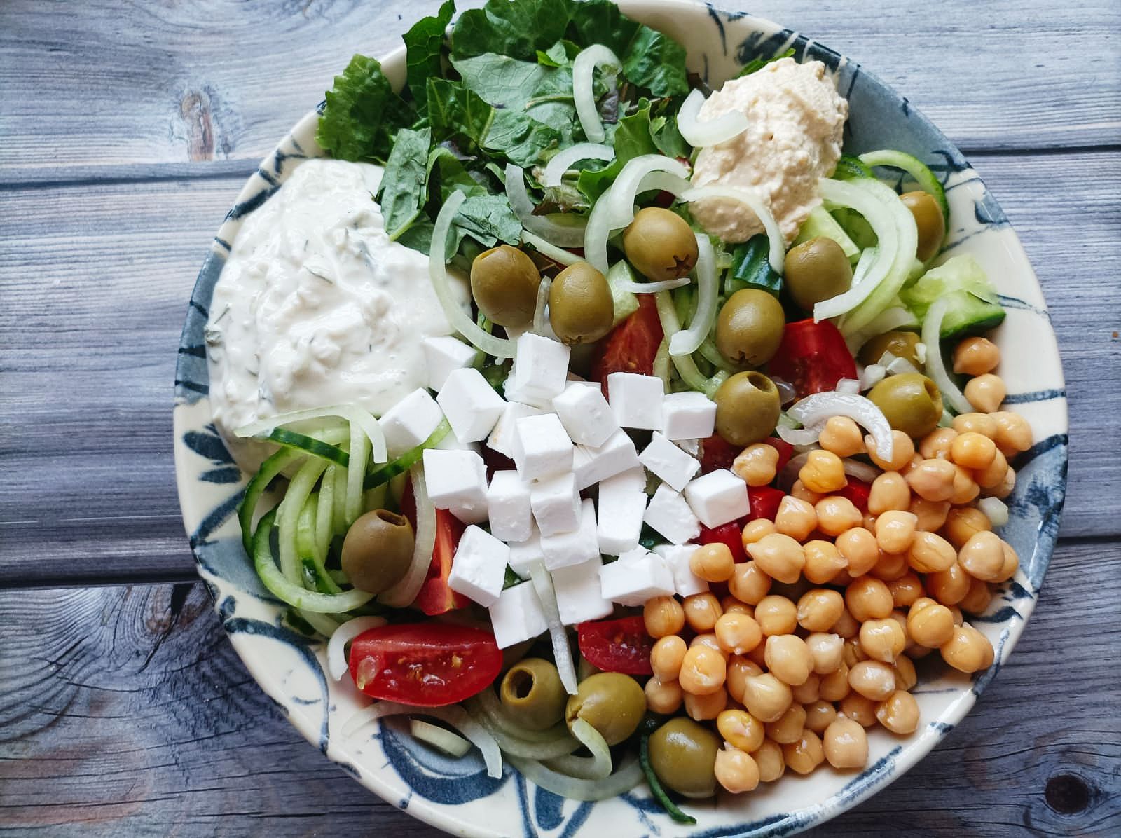 salad bowl with chickpeas, olives, and vegan cheese