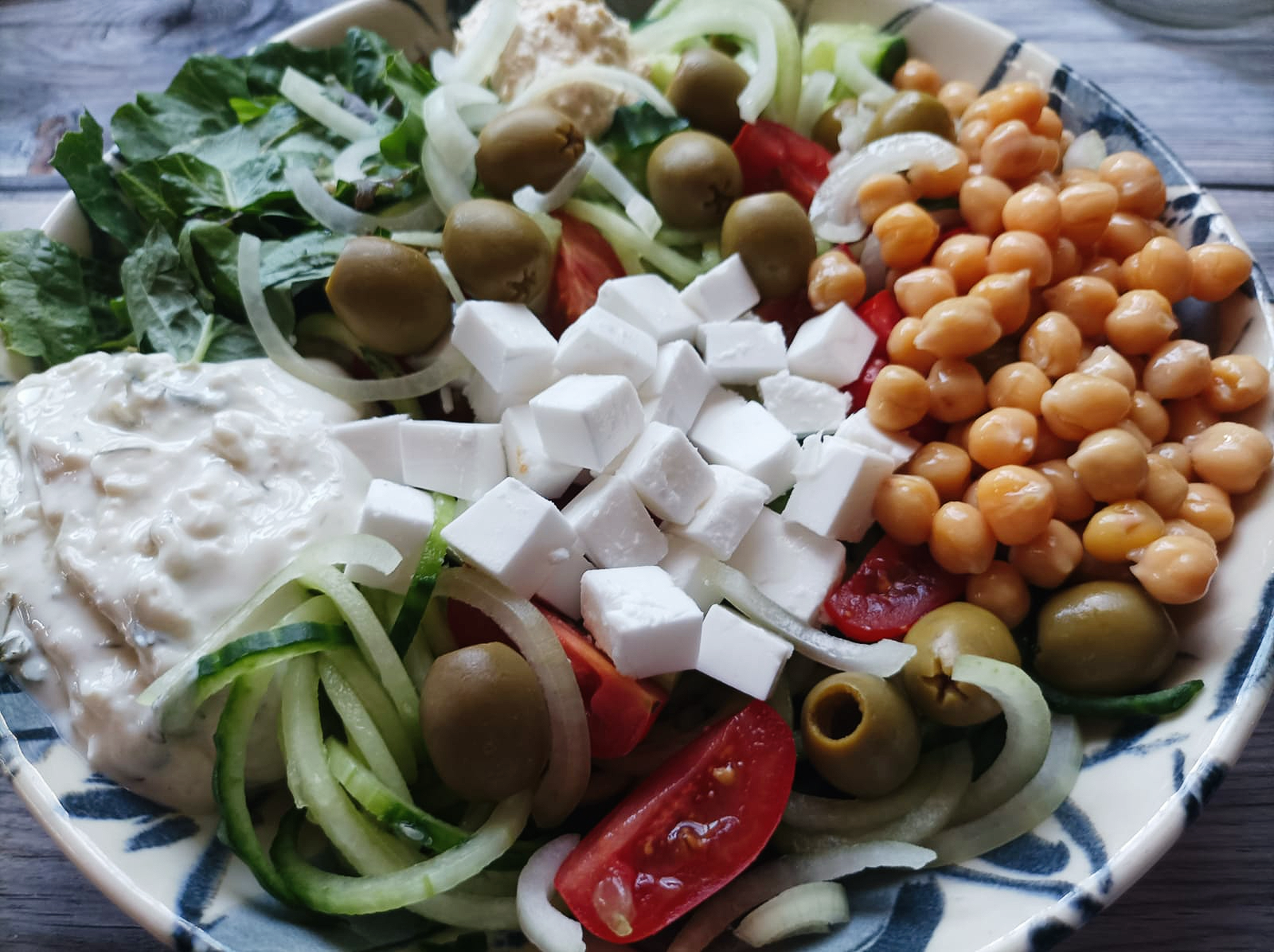 salad bowl with chickpeas, olives, and vegan cheese