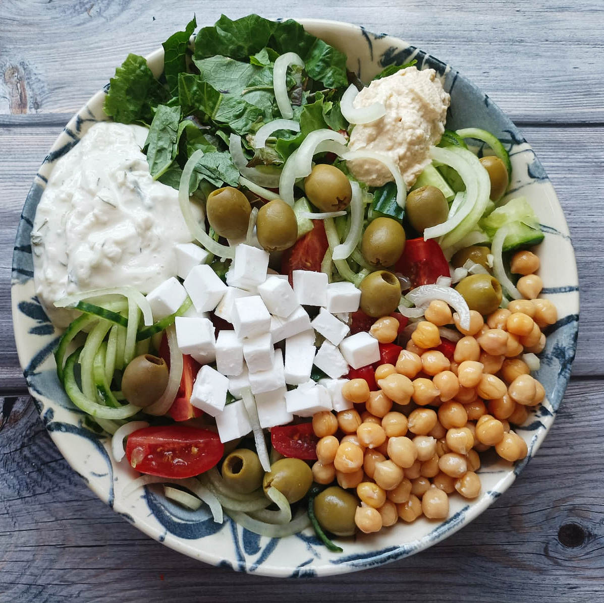 salad bowl with chickpeas, olives, and vegan cheese