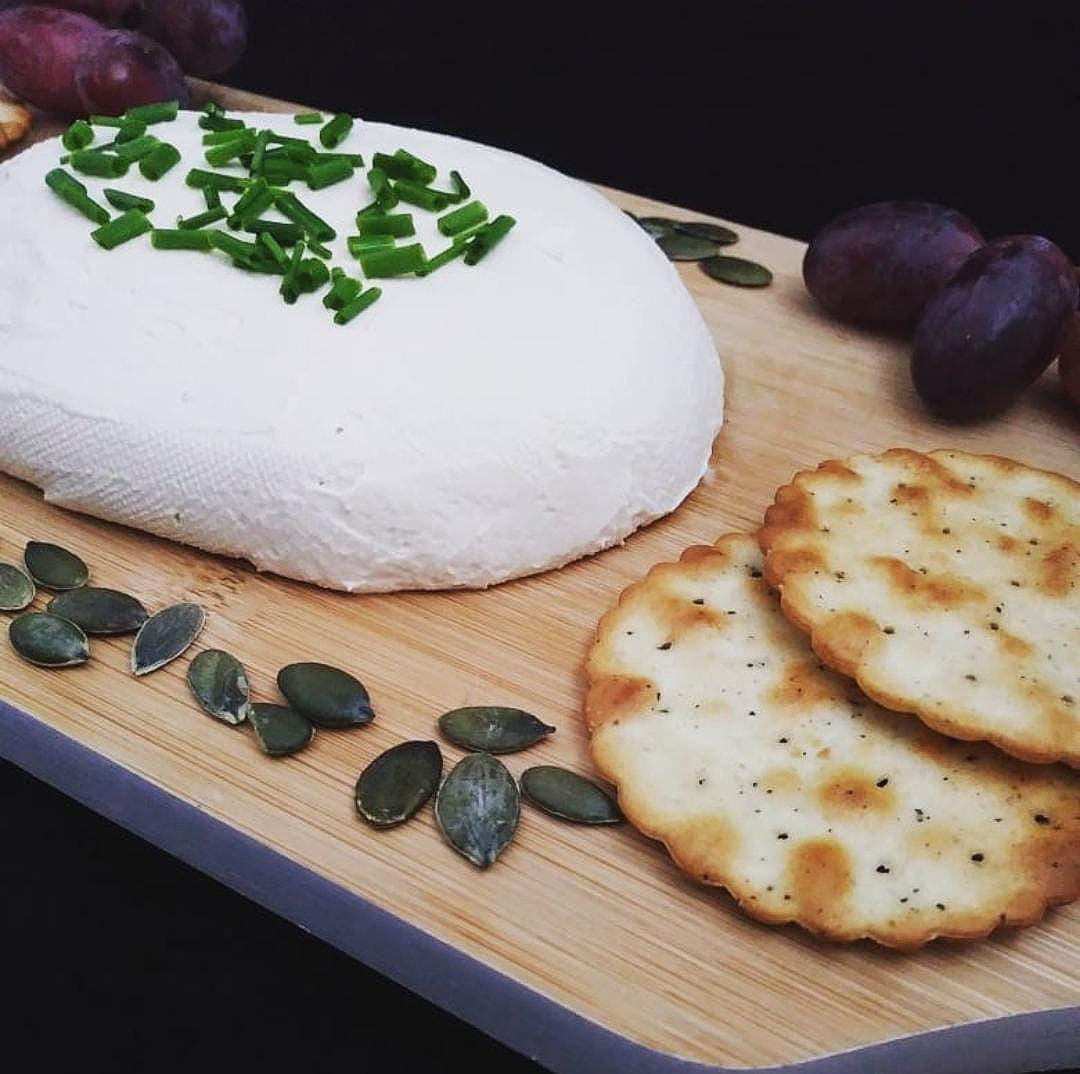 vegan cheese on a board with crackers, pumpkin seeds, and grapes