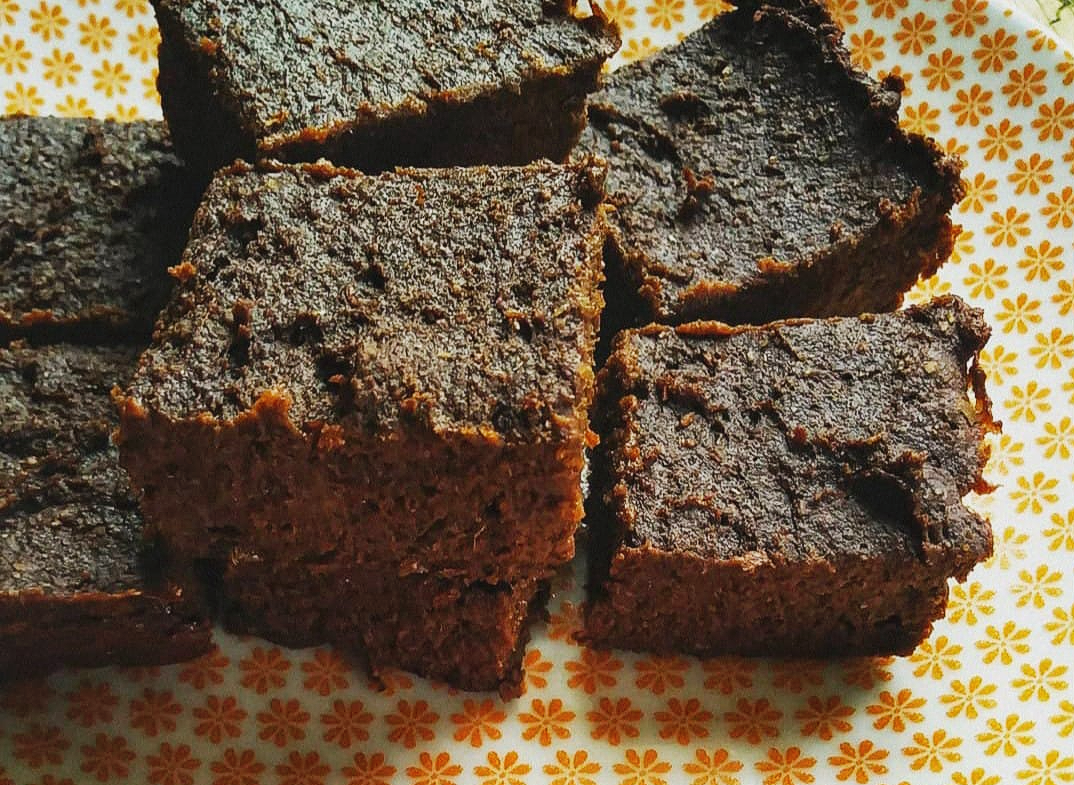 chocolate brownies on a plate with orange flowers