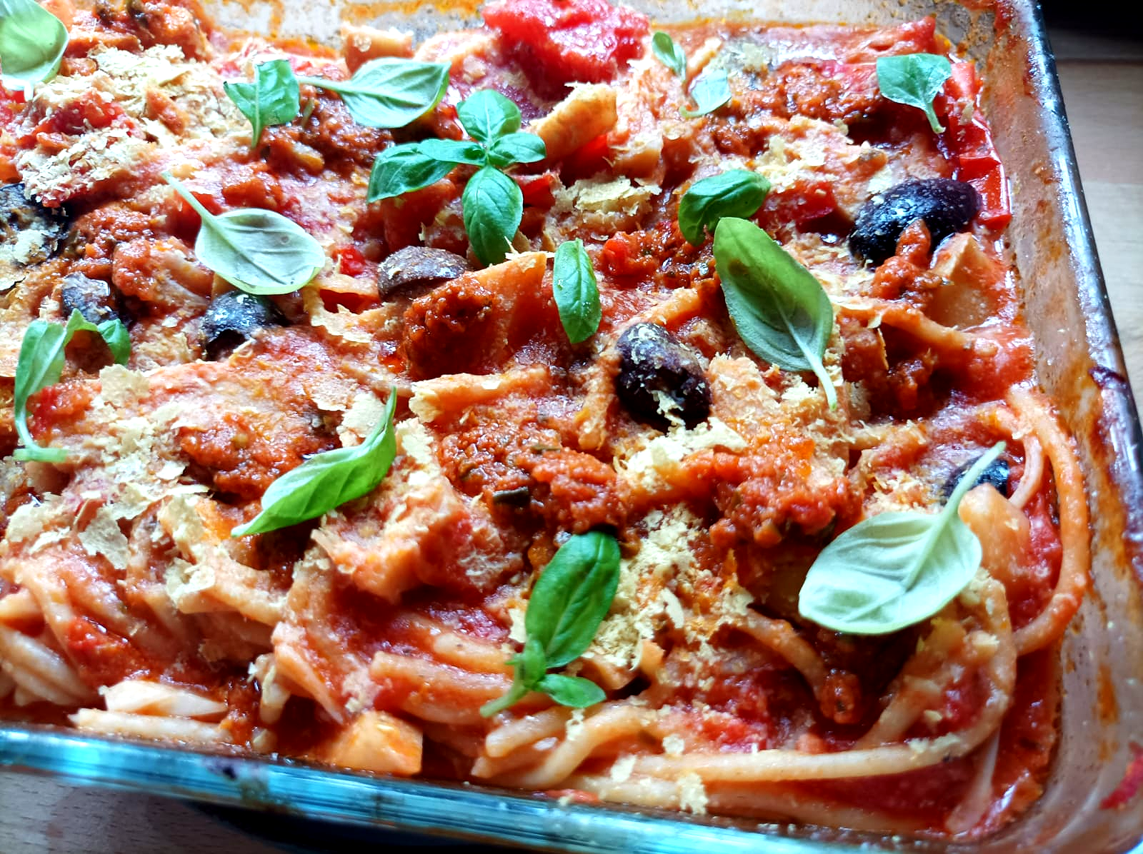 spaghetti pasta bake on a plate with basil on top