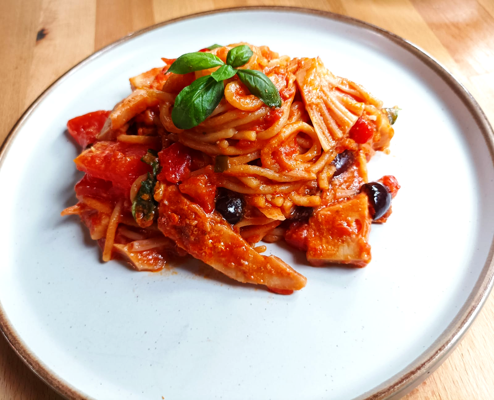 spaghetti pasta bake on a plate with basil on top