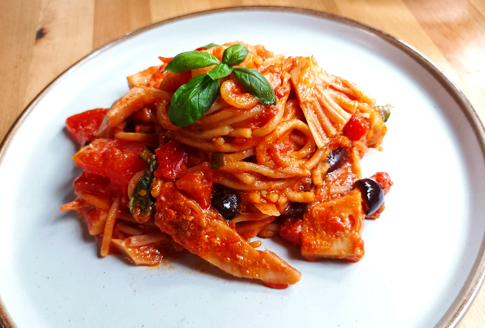 spaghetti pasta bake on a plate with basil on top