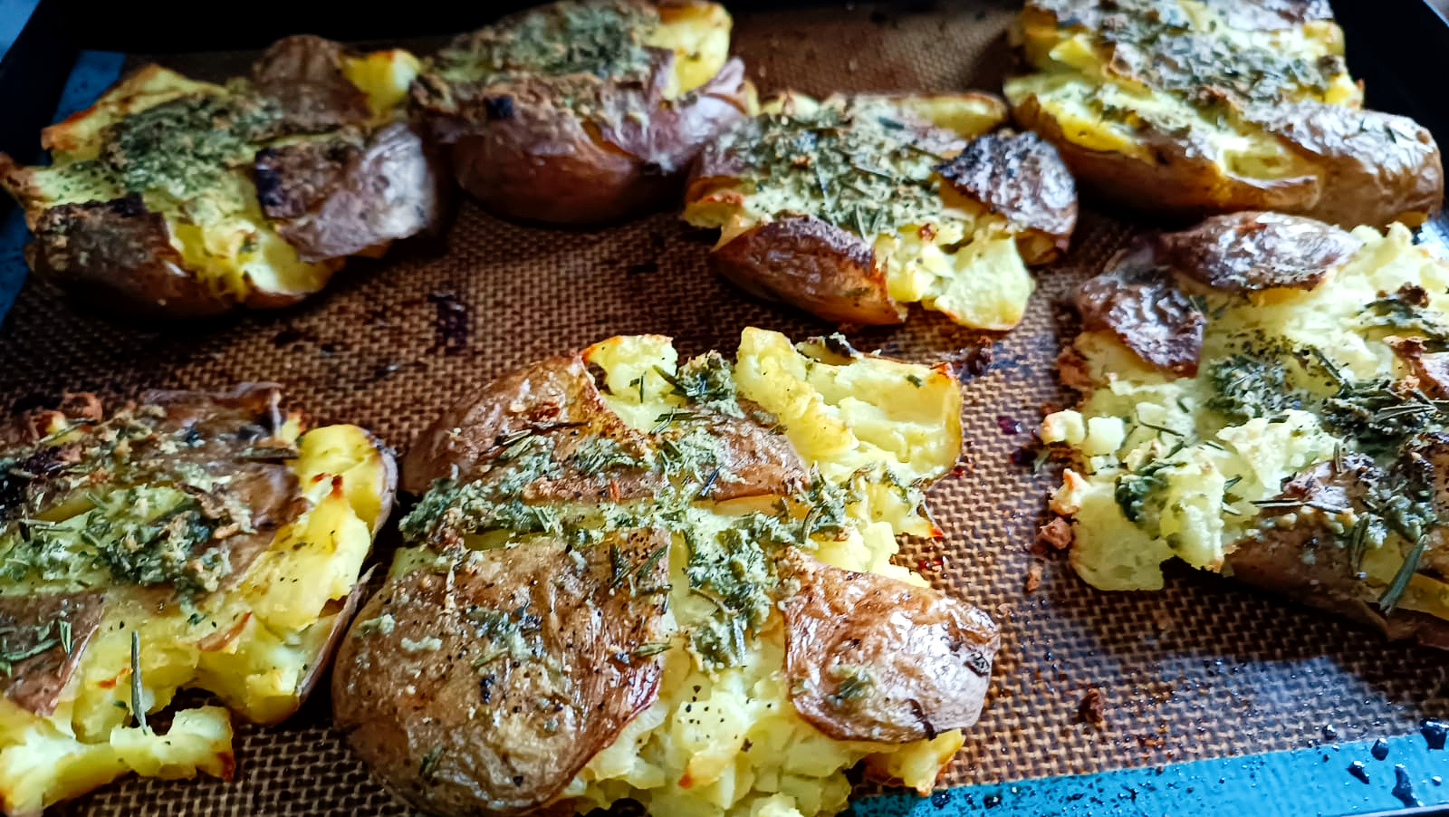 Roasted potatoes on a baking tray with rosemary and garlic