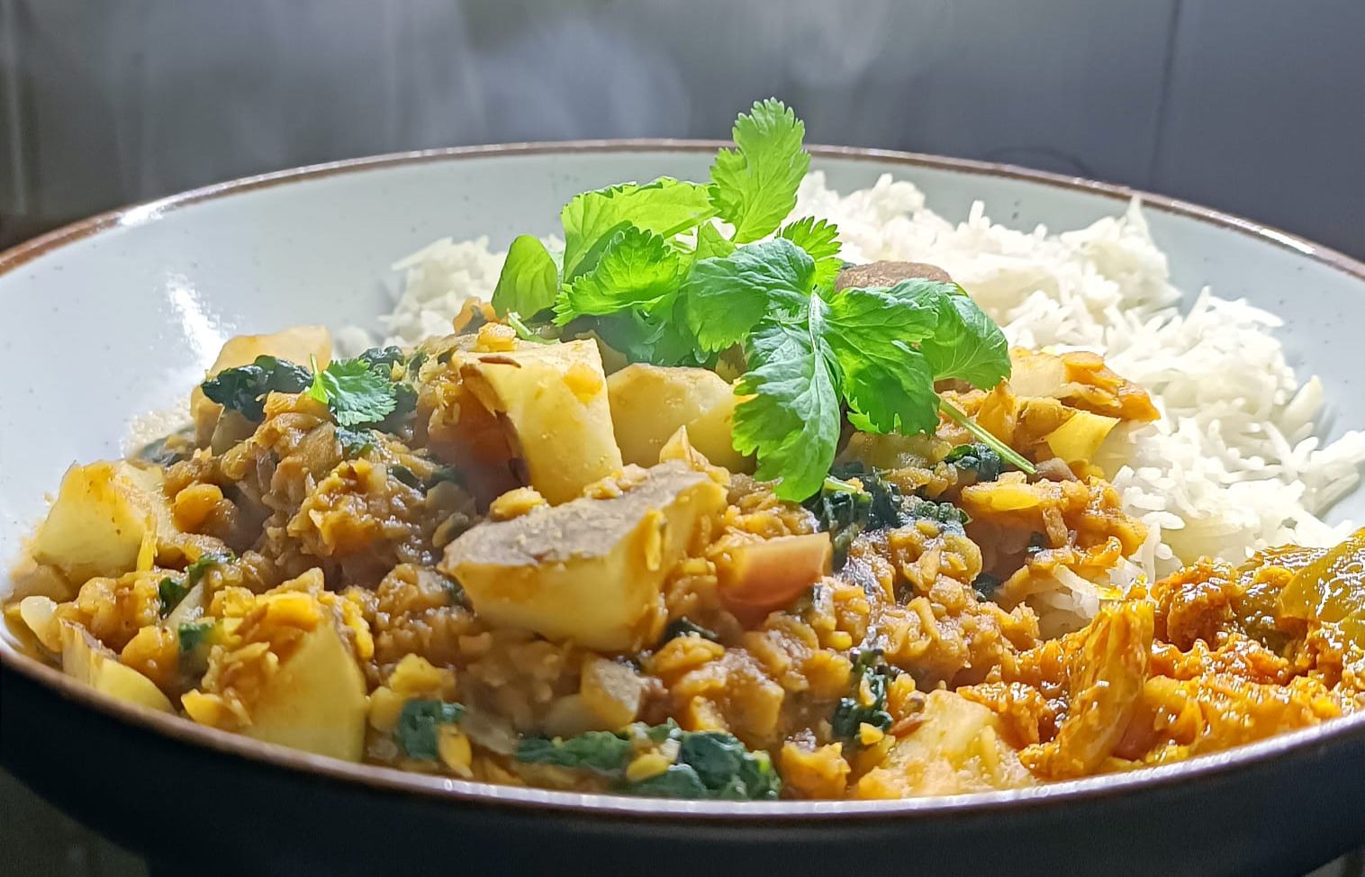 lentil dal curry with rice, lime pickle, and topped with fresh coriander