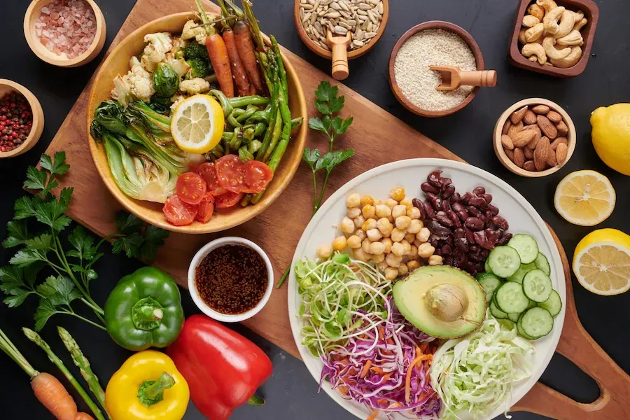 Big bowls of salads with beans, avocado, nuts, seeds, fresh lemon, and salad vegetables