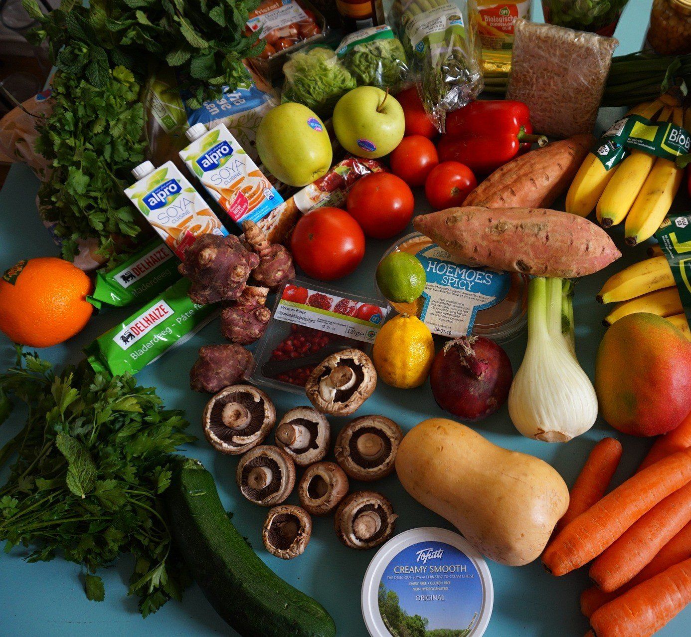 shopping haul on a table with vegetables fruits and other groceries