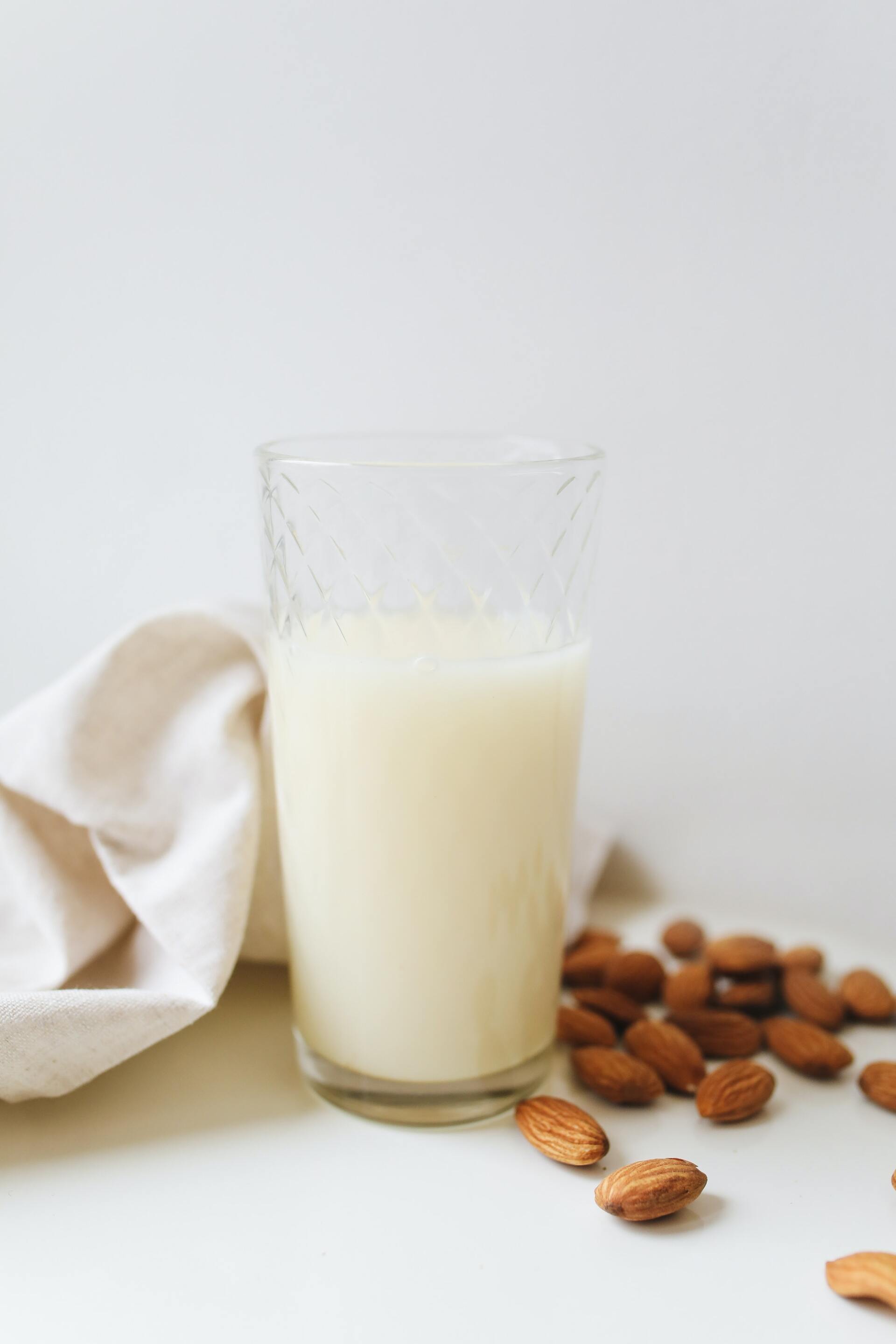 glass of almond milk with almonds alongside