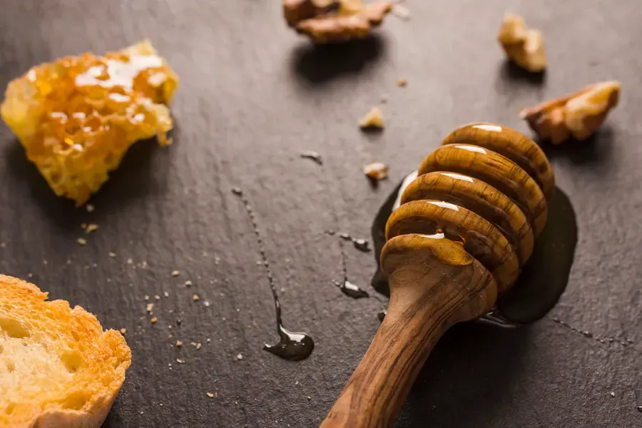 spilled honey on a table with honeycomb