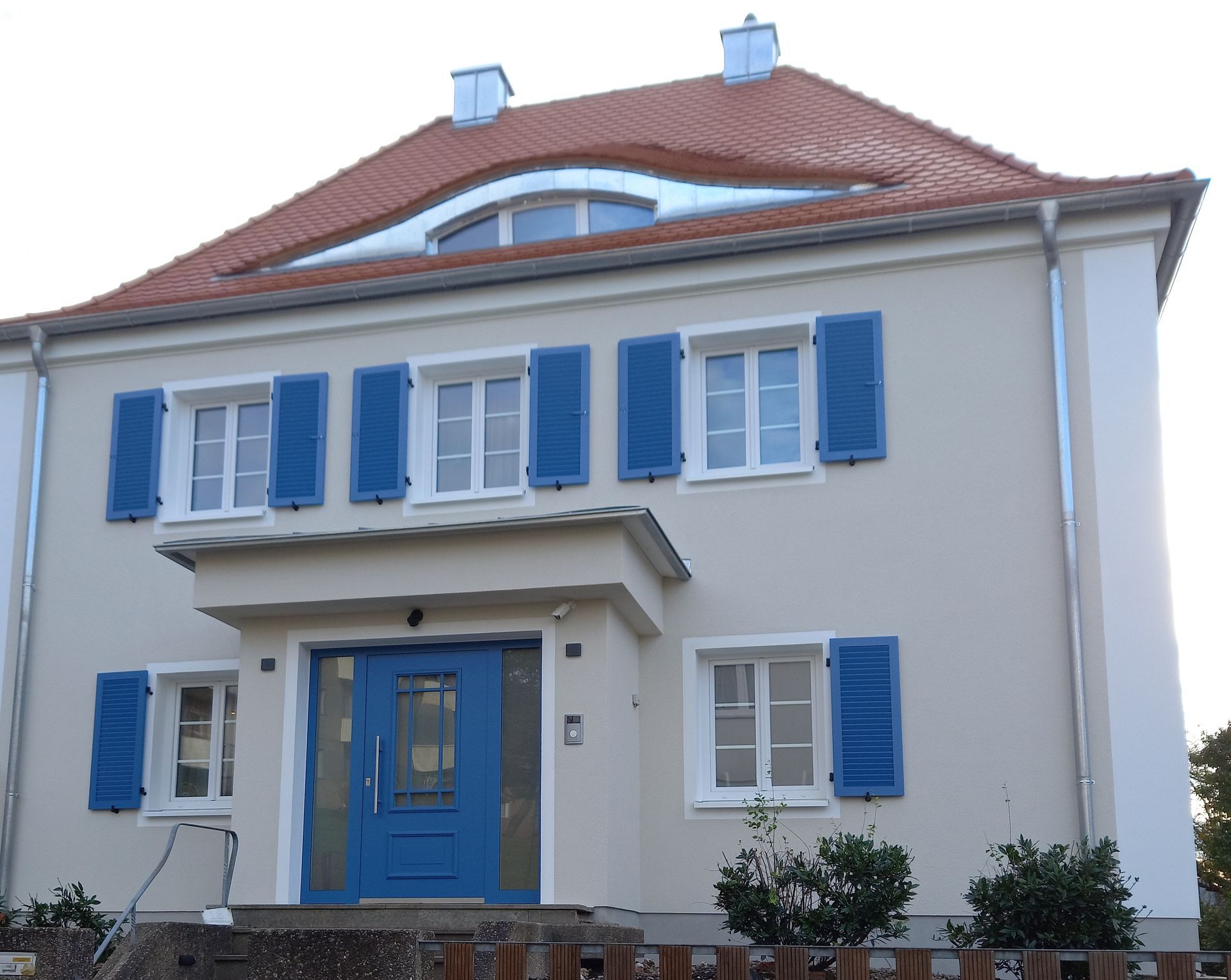 RAL 5007 pulverbeschichtete Fensterläden mit Lamellen montiert an Fassade