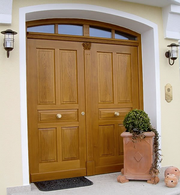 Zweiflügelige Landhaustüre in Eiche mit Kapitell, Kasetten und Oberlicht als Segmentbogen