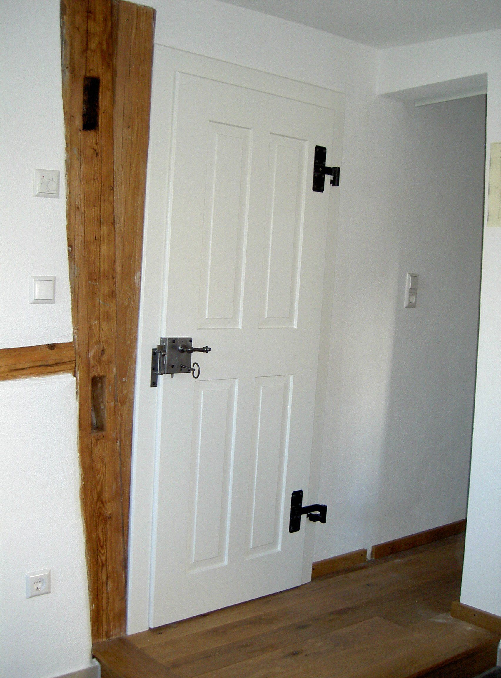 Kastenschloss und geschmiedete Bänder montiert auf weißer Landhaustüre