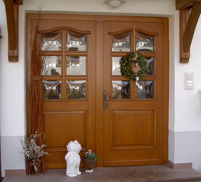 Rustikale Holztüre mit Schweifbogen und gewölbten Gläsern