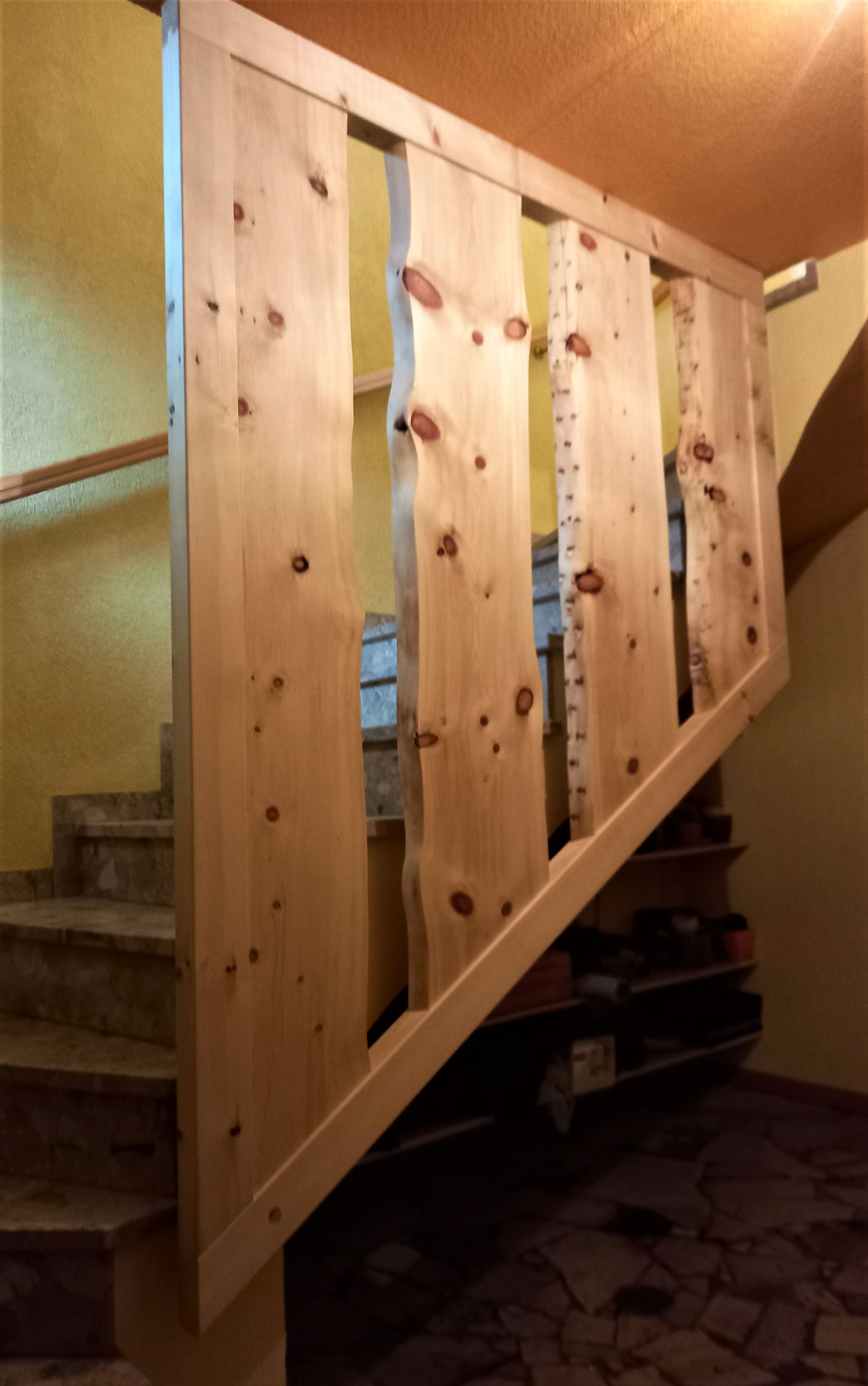 Treppengeländer aus Zirbelkieferbretter mit Baumkanten in Harfeform
