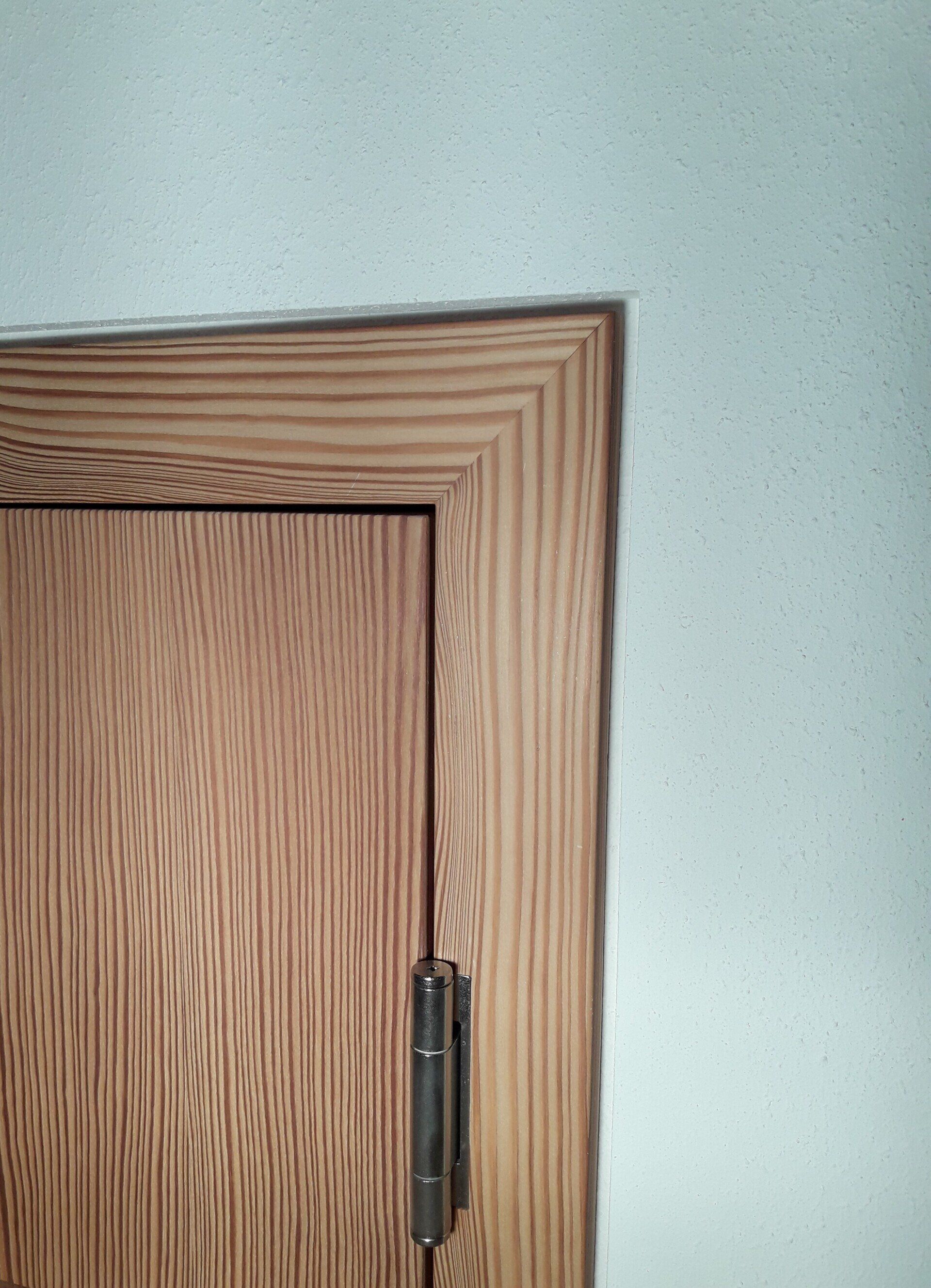 Wandflächenbündige Türzarge mit sichtbaren Band und umlaufender Schattenfuge mit Ansicht von innen