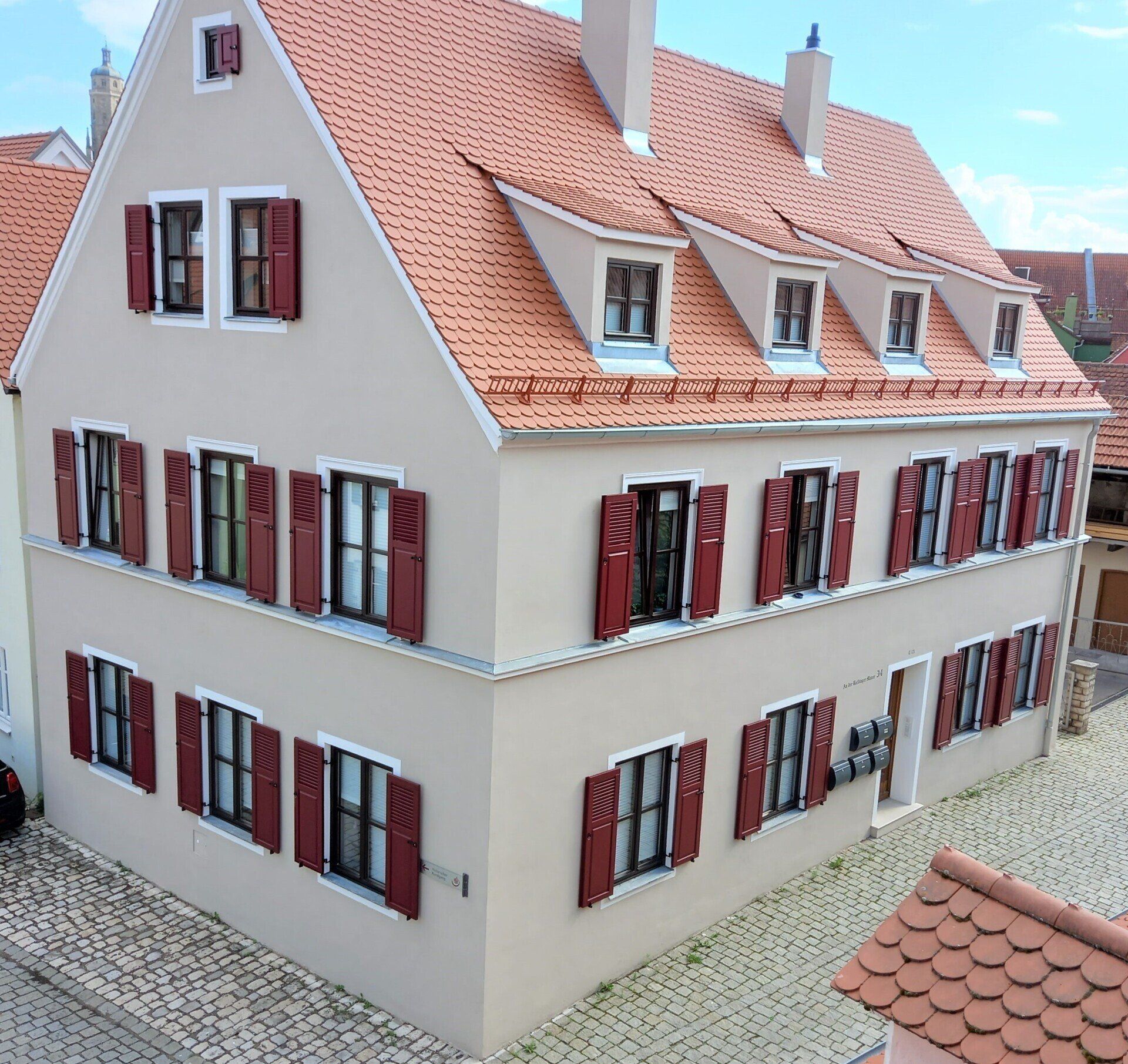 Wohnhaus mit roten Holzfensterläden als Klappläden mit Jalousie und Füllung