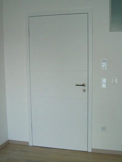 Flächenbündige Weißlacktüre mit Hohlkehlenfräsungen, verdeckten Schließblech, verdeckt liegenden Bändern und flächenbündigen Rosetten