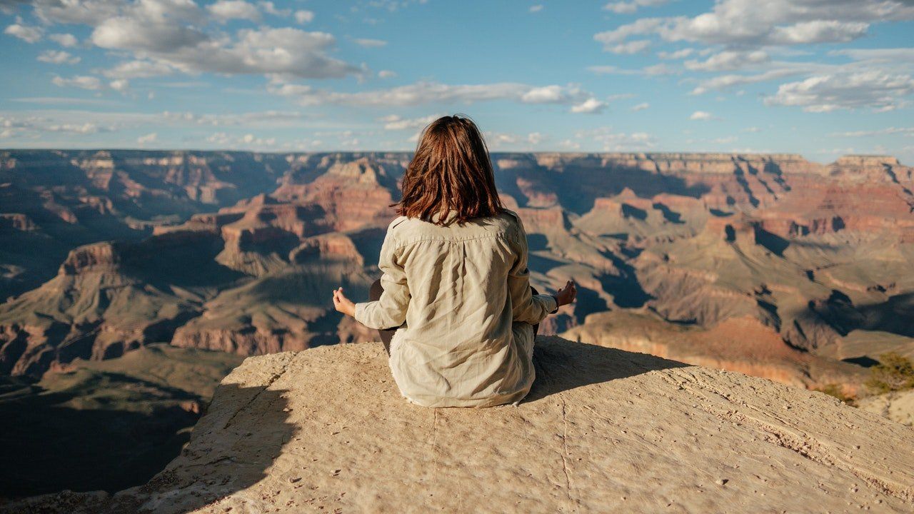 Femme méditant devant le grand canyon