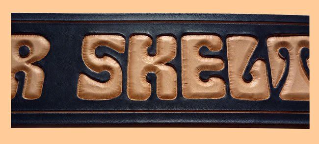 Helter-Skelter Schriftzug auf Gitarrengurt punziert