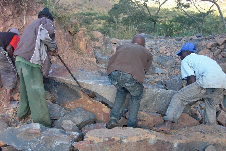 Bildhauer in Zimbabwe beim Verladen von Rohstein