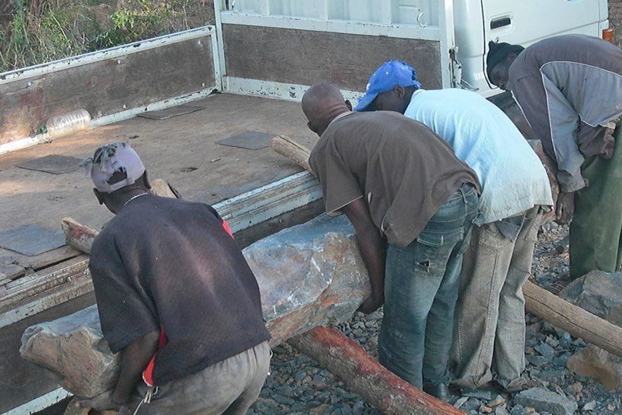Bildhauer in Zimbabwe beim Verladen von Rohstein