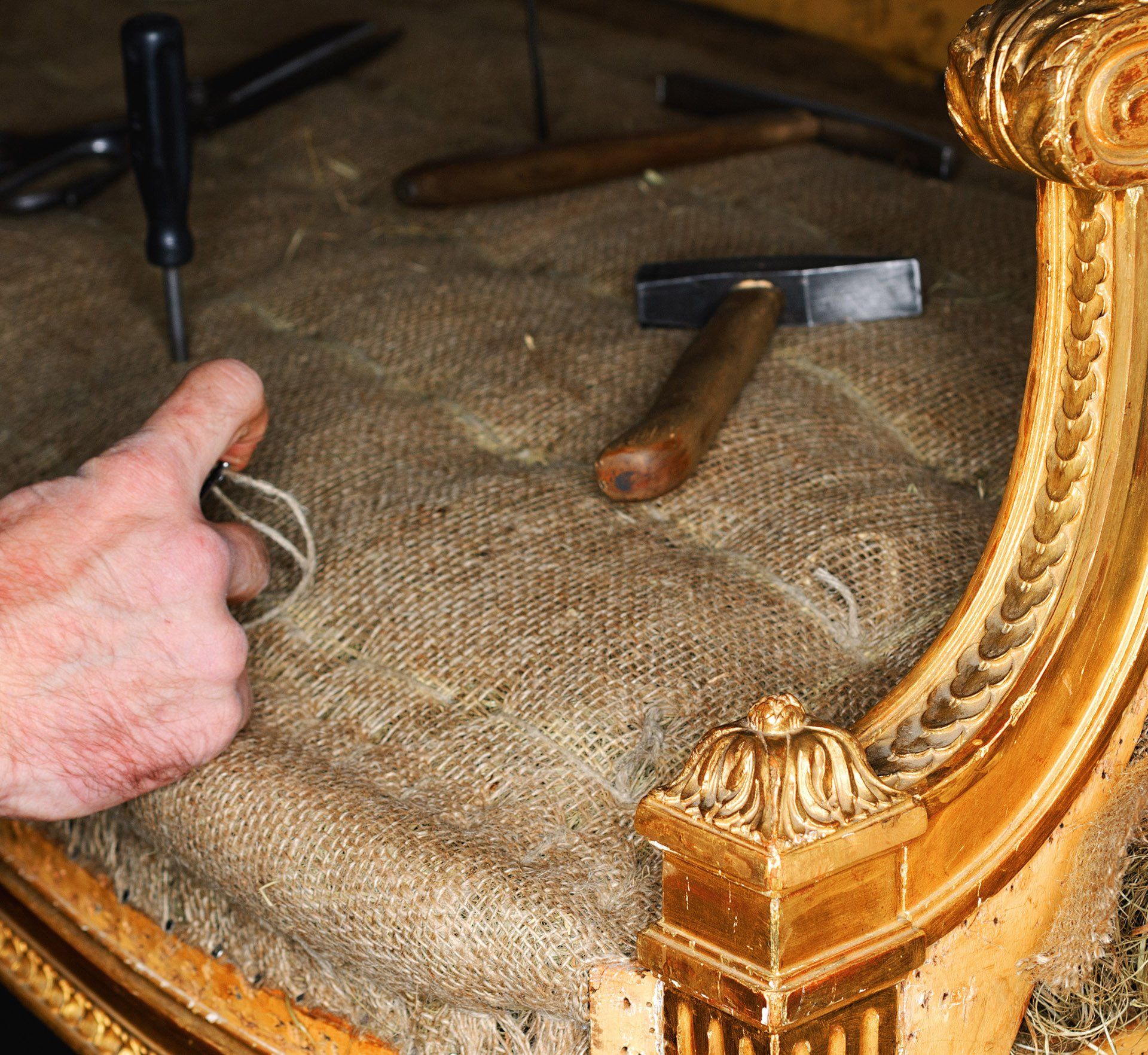 Upholsterer working with tools on chair repair
