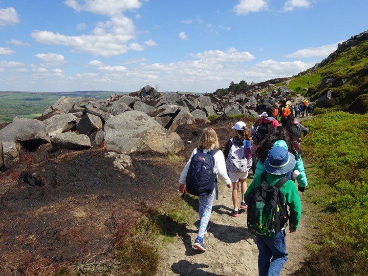 Picture of children walking on ilkley moor with one of Nell Bank outdoor learning centre programmes