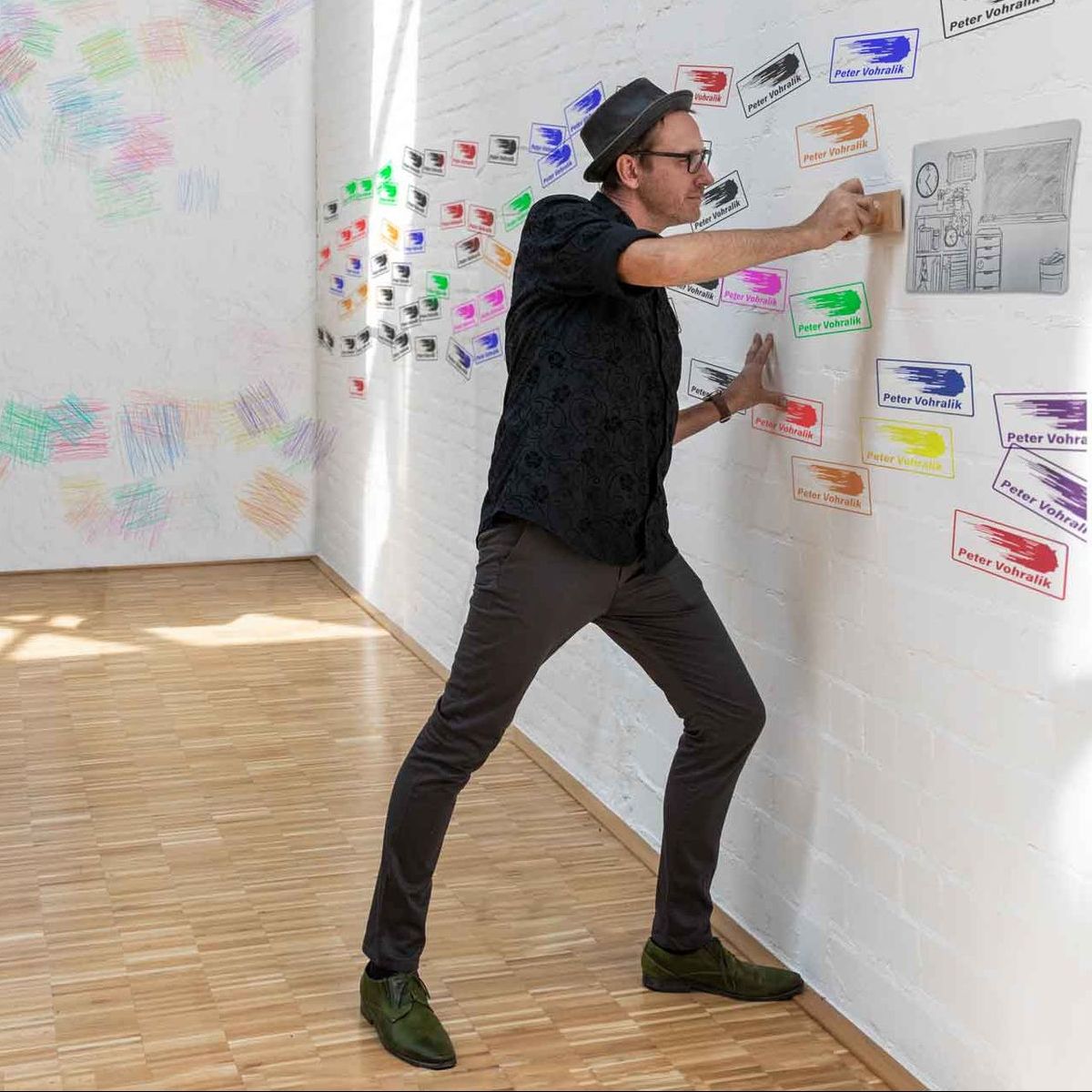Peter Vohralik stempelt sein Logo auf die Wand