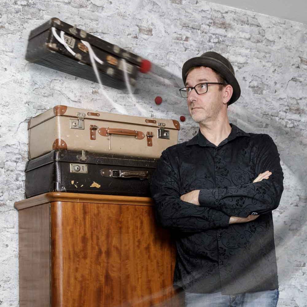 Zauberkoffer schwebt hinter Zauberer in die Luft