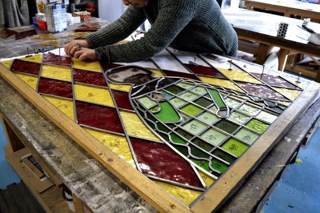 leading up a stained glass window in the workshop